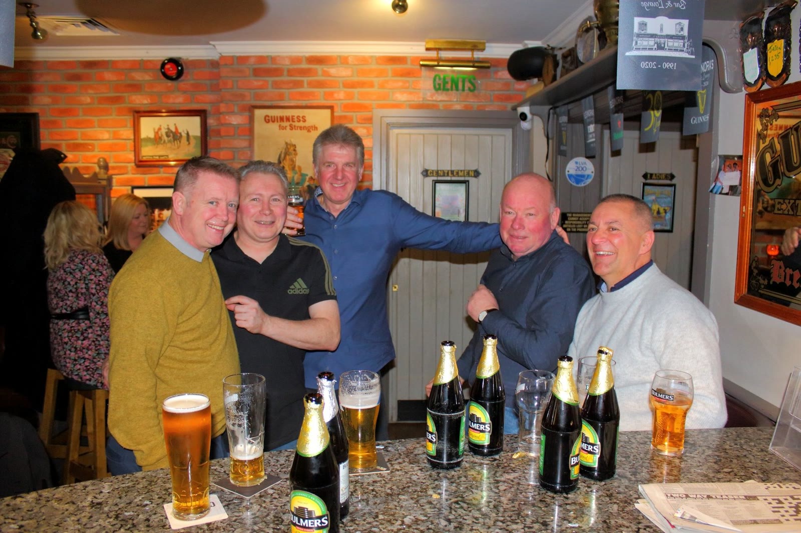 Friends with pints at a table in the bar