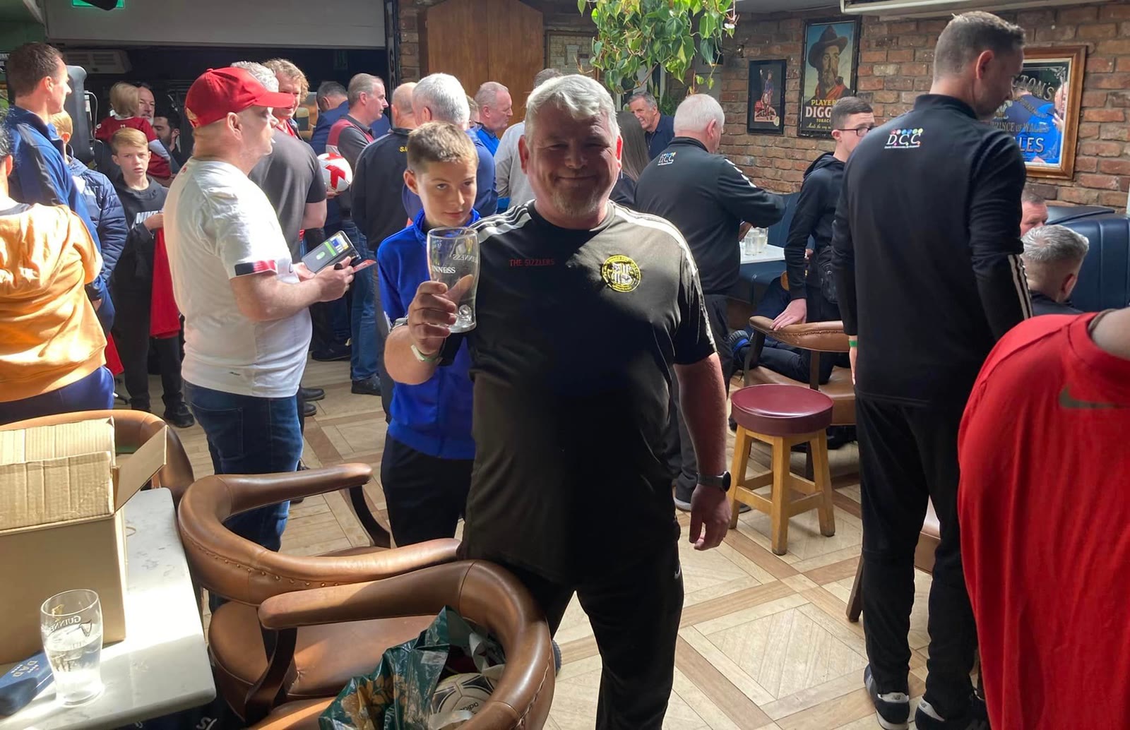 A busy night at the bar, a regular raising his pint to the camera