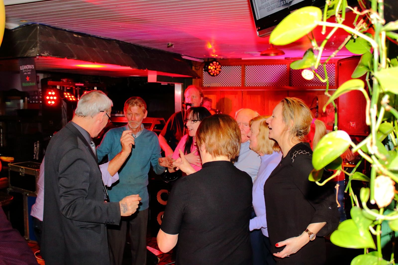 People dancing under red and green lights in the lounge