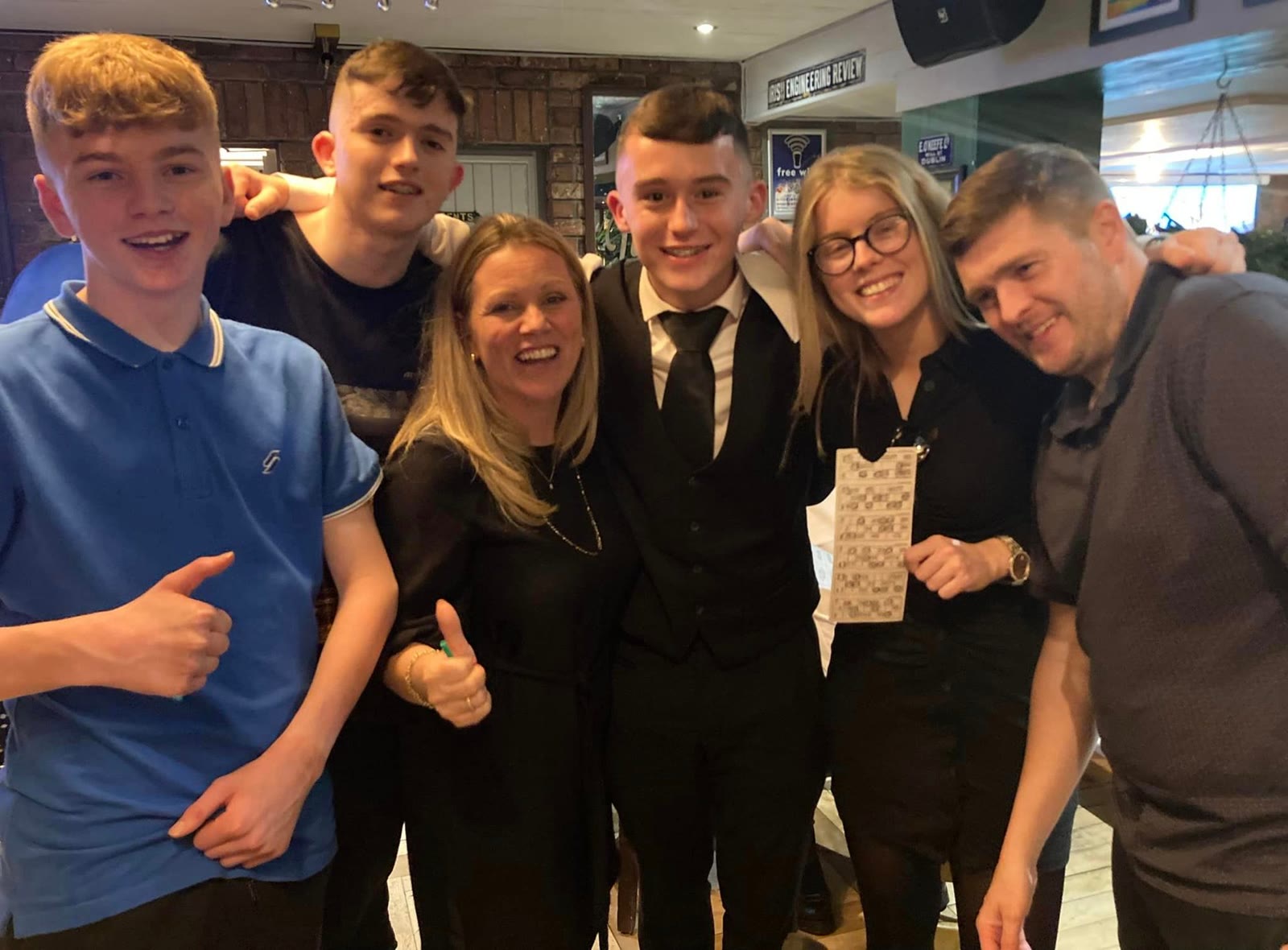 A family giving the thumbs up in the lounge