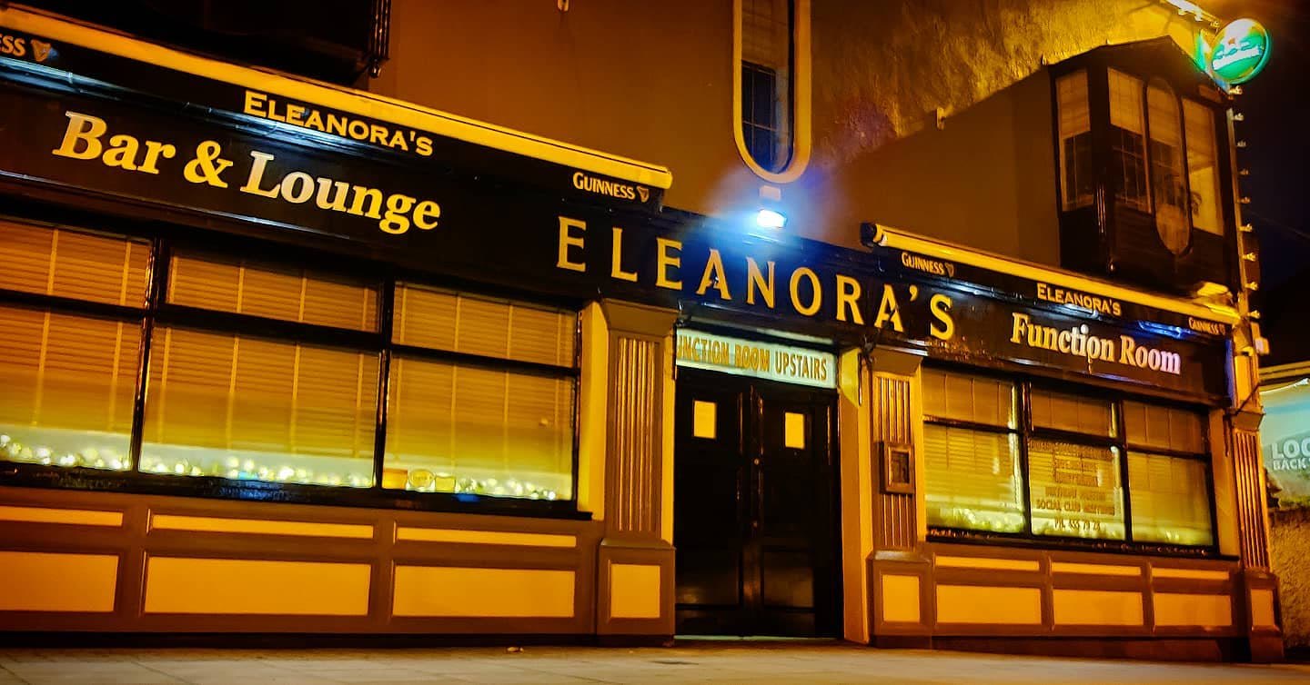 The Eleanora's sign lit gold at night over the bar, lounge and function room doors