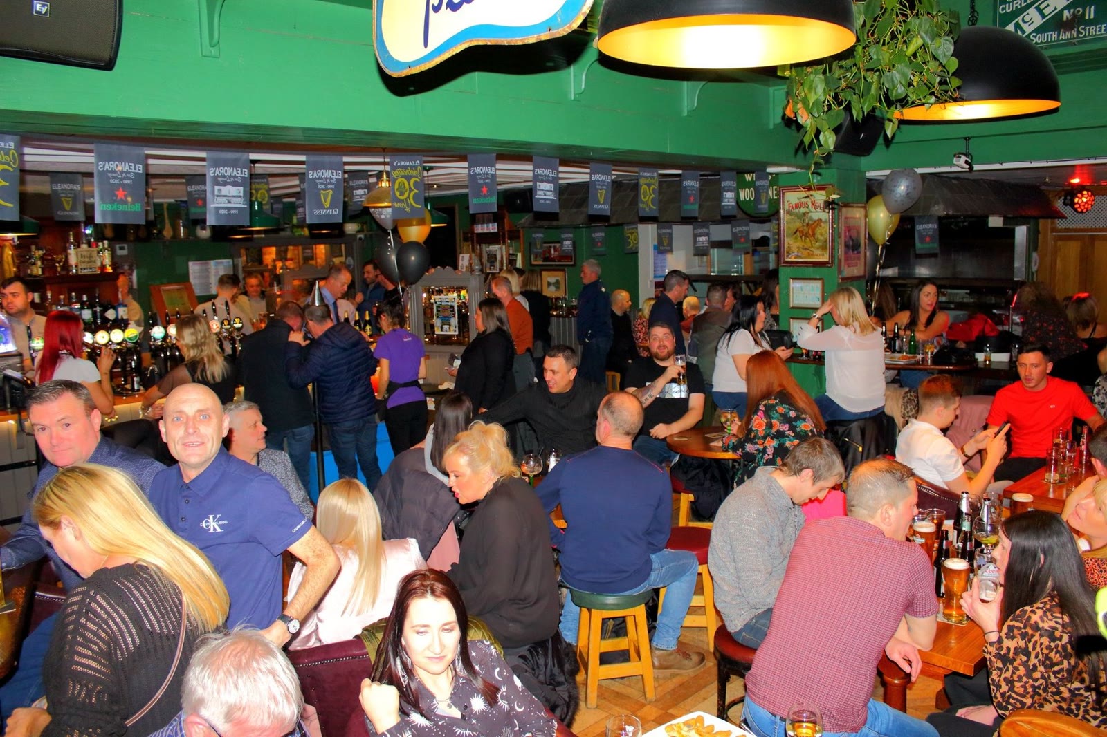 A packed lounge under the green ceiling