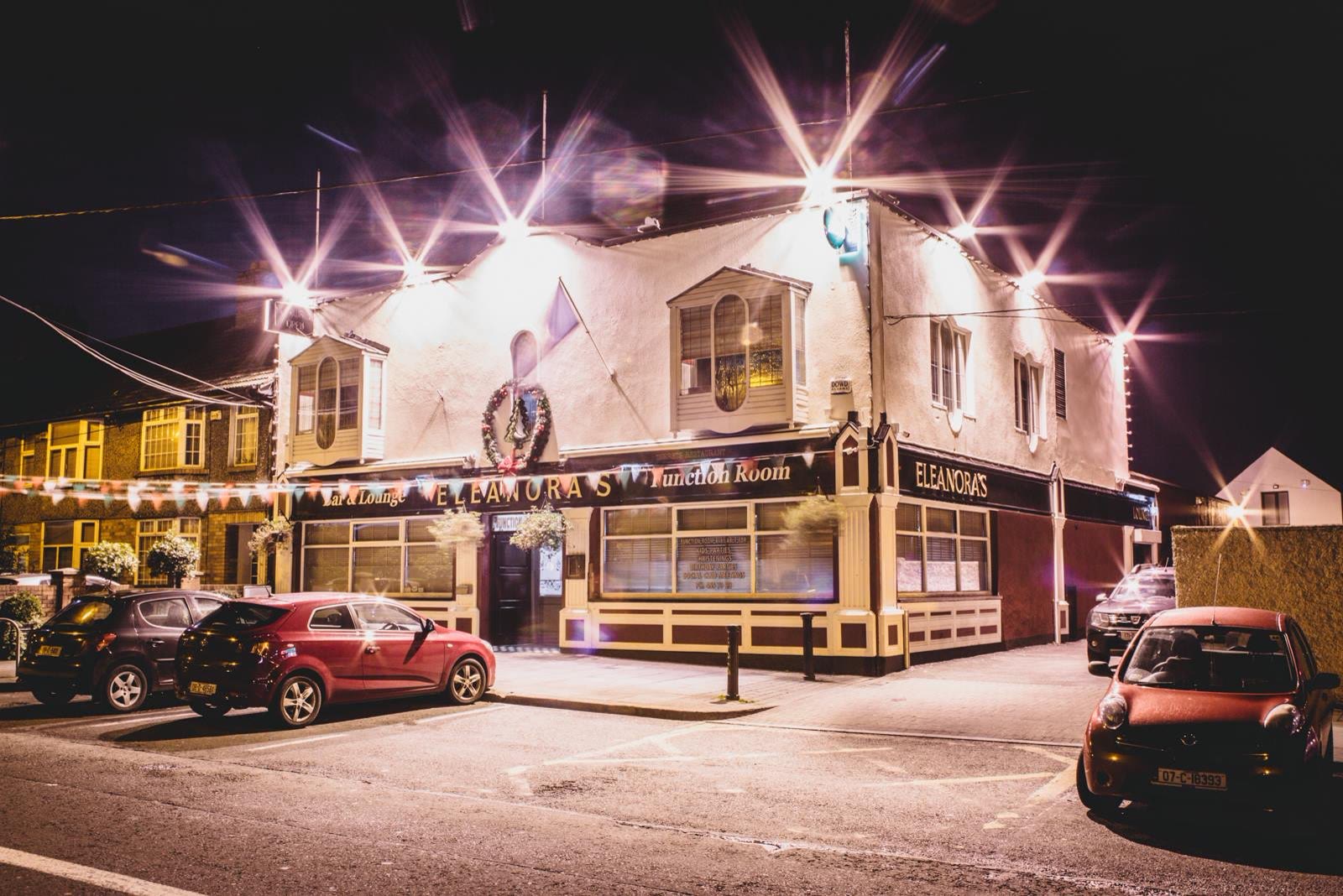 Eleanora's on Drimnagh Road at night, its bar and lounge lit up behind the cars