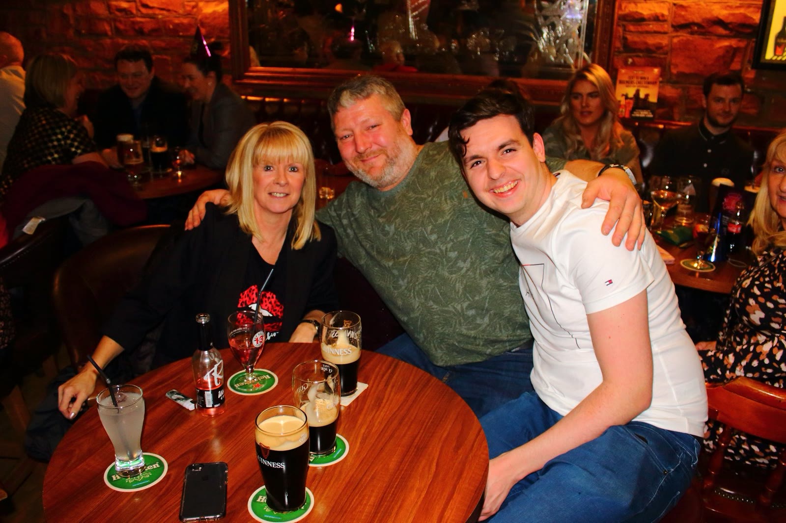 Three friends at a round table with pints of stout