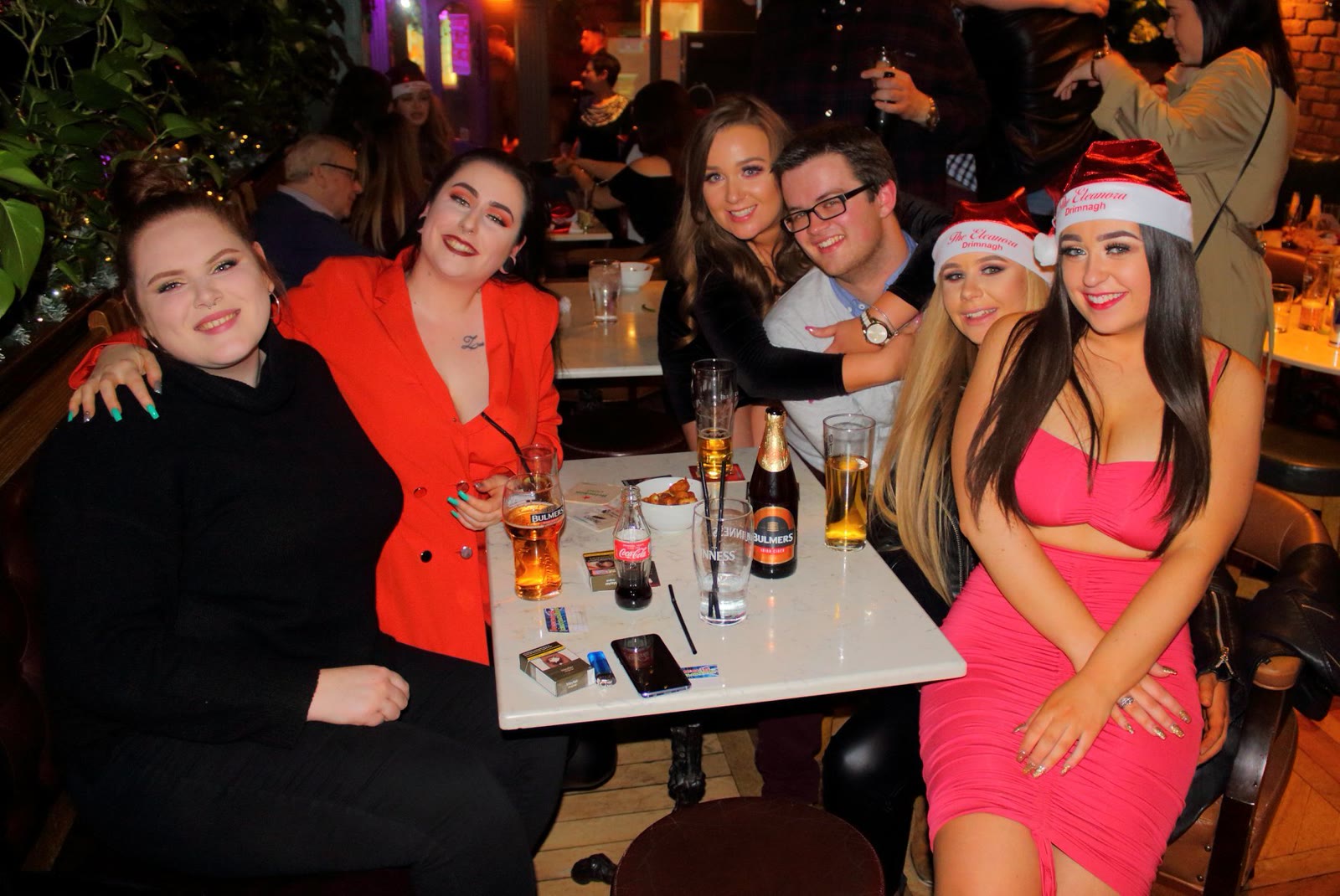 Friends in Christmas hats at a table